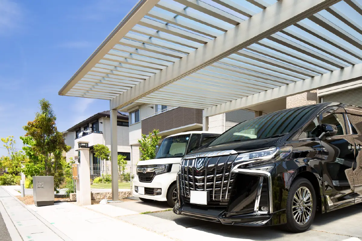 青空の下の駐車場に停車している二台の自動車