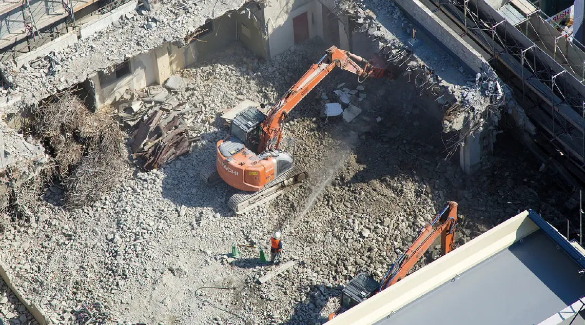 建物を解体中のオレンジ色の重機